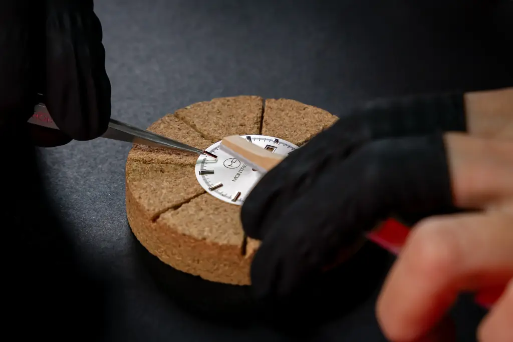 Artisan horloger ajustant un cadran de montre avec des outils de précision