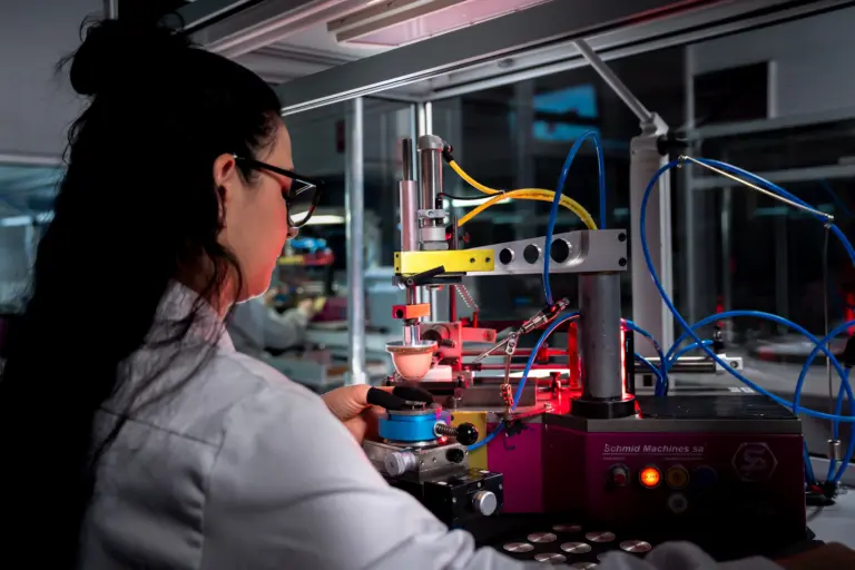 Opératrice Montremo réglant une machine de tampographie pour imprimer chiffres et logo sur un cadran de montre