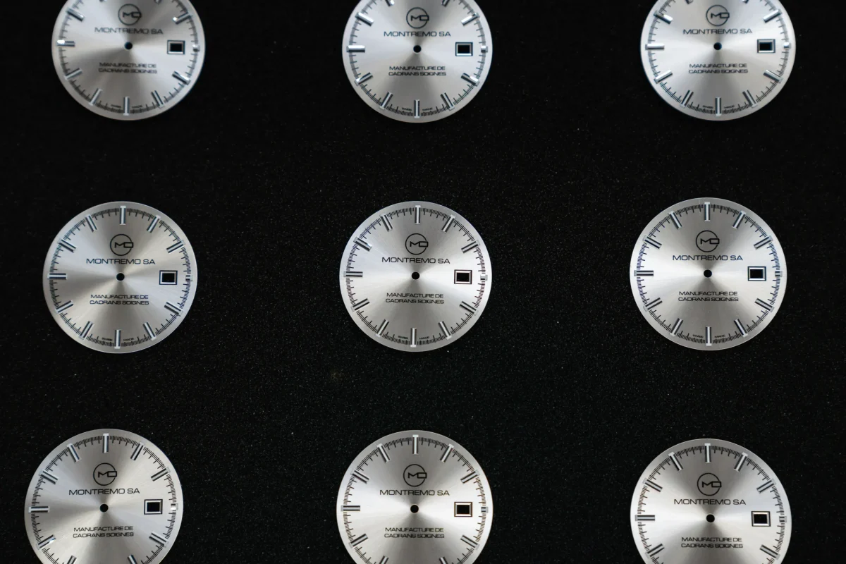 Série de cadrans Montremo disposés sur fond sombre, symbolisant la discrétion, la loyauté et la précision de la manufacture